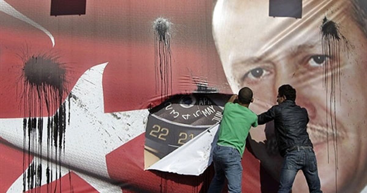 Ліван, Бейрут. Ліванські вірмени розривають плакат із портретом
прем'єр-міністра Туреччини Реджепа Тайіпа Ердогана у центрі Бейрута на
знак протесту проти візиту Ердогана до Лівану. Вірмени стверджують, що
щонайменше 1,5 мільйона вірменів були знищені під час систематичних
акцій у 1915-17 рр., коли розвалювалась Османська імперія, попередник
сучасної Туреччини. / © AFP