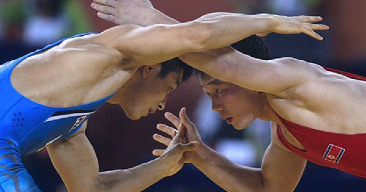 Китай, Гуанчжоу. Спортсмен з Північної Кореї Ян Чун Сонг (праворуч) і південнокорейський борець Кім Дай-Сена під час 1/8 фіналу з вільної боротьби на Азіатських іграх у Гуанчжоу. / © AFP