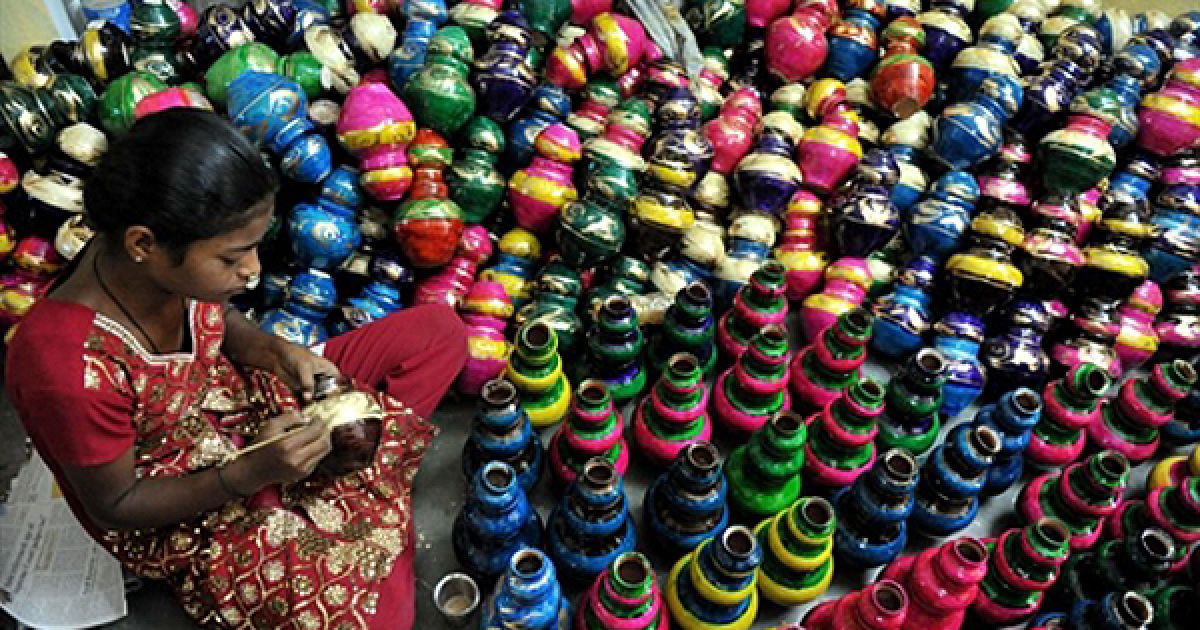 Майстриня фарбує ліхтарики &laquo;ділі&raquo;, які будуть прикрашати галявини під час свята Дівалі, у своїй майстерні на окраїні Хайдерабада. Ці ліхтарики стали одним з найпопулярнішим товарів у Індії, оскільки Дівалі, свято перемоги бога Рами над злим богом Раваною, є центральним святом індуїстів. / © AFP