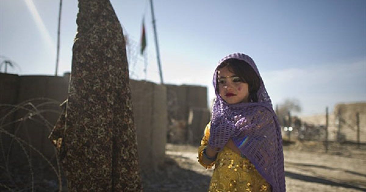 Афганістан, Муса-Кала. Афганська дівчинка та її матір гуляють поруч із базою Муса-Кала, провінція Гільменд. Афганістан страждає від низького рівня освіти, особливо серед дівчаток, низького рівня грамотності тощо. Країна також має другий у світі найгірший показник зі смертності немовлят. / © AFP