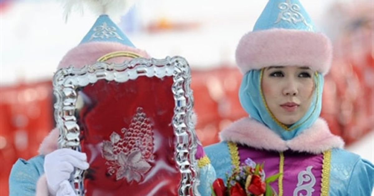 Казахстан, Алмати. Дівчата допомагають під час церемонії нагородження переможців змагань зі швидкісного спуску на 7-их зимових Азіатських іграх в Алмати. / © AFP