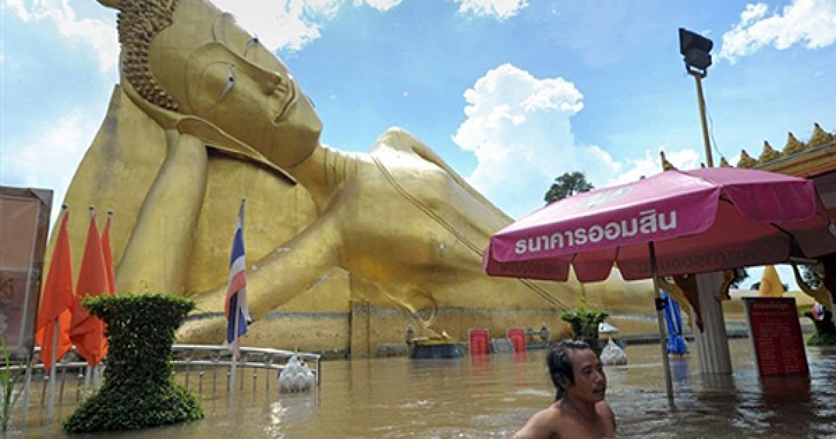 Чоловік пливе крізь затоплену центральну площу Аюттхаї. Таїланд вже 2 тижні страждає від повені, викликаної зливами. Кілька мільйонів таїландців втратили свої домівки, переважна кількість сільськогосподарських угідь у північних провінціях повністю знищено. / © AFP