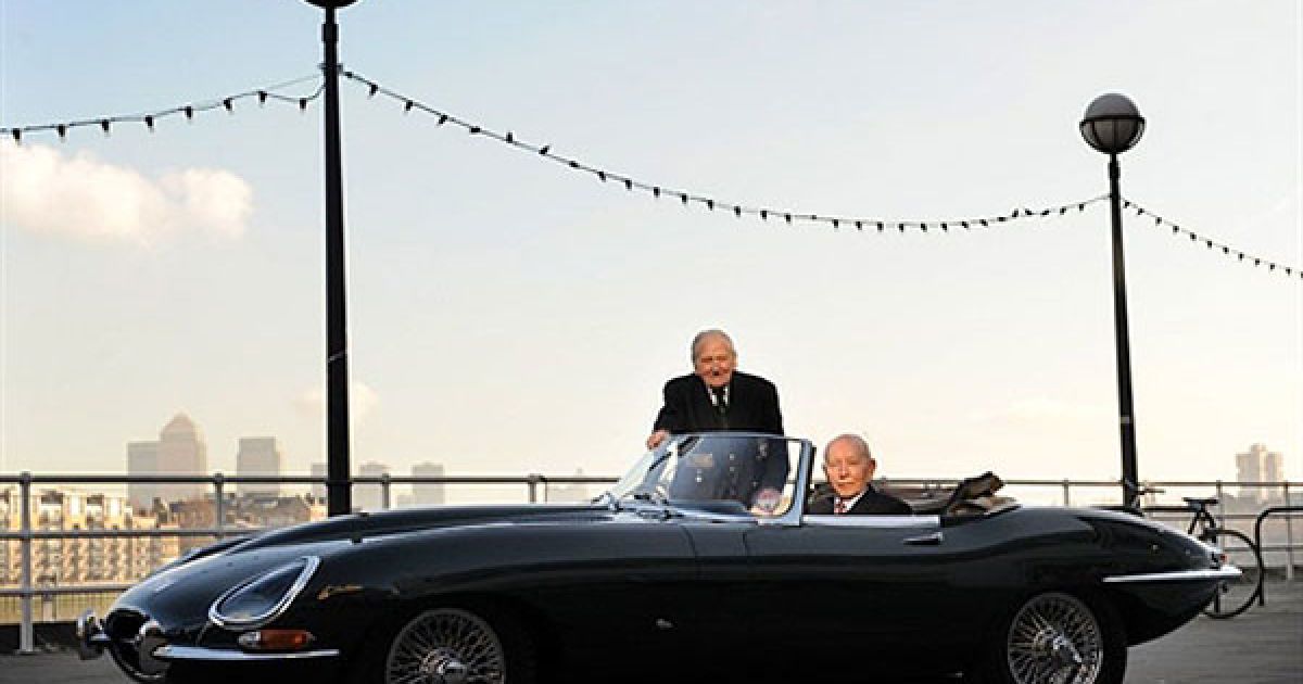 Великобританія, Лондон. Колишній тест-пілот Jaguar E-Type Норман Девіс і колишній чемпіон світу з F1 Джон Сертіс позують для фотографів поруч зі спортивним Jaguar E-Type 77 RW 1961 року випуску. Компанія Jaguar відзначає 50-річчя спортивного автомобілю спортивним Jaguar E-Type в Музеї дизайну у Лондоні. / © AFP