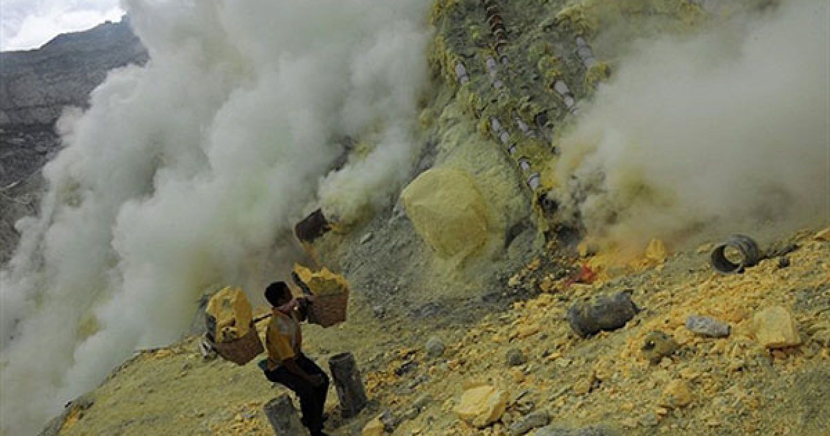 Індонезія. Індонезійський шахтар піднімає кошики з сіркою від нижньої частини кратера діючого вулкана Кайа Айвен на крайньому сході острова Ява в Індонезії. Близько 350 гірників, що видобувають сірку, живуть поблизу діючого вулкана. / © AFP