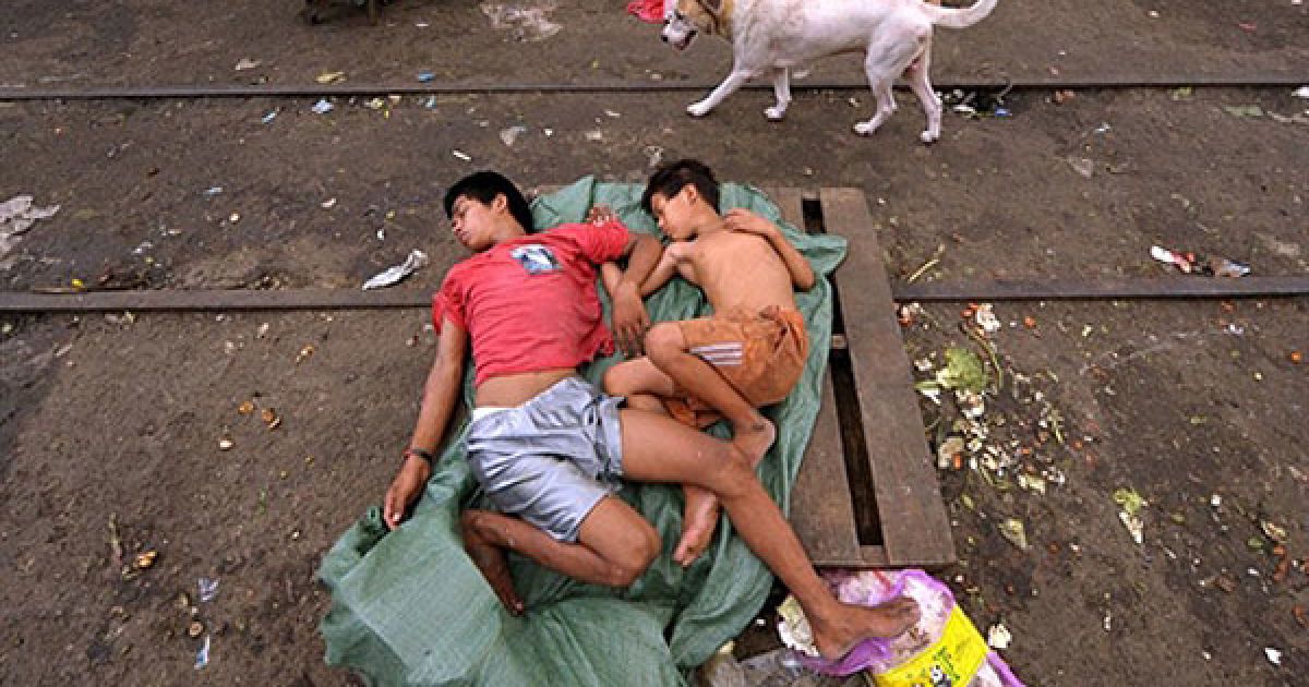 Філіппіни, Маніла. Двоє дітей сплять на дерев'яній палеті на ринку Дівісорія у Манілі. Економічне зростання у країні сповільнилося протягом літнього періоду. / © AFP