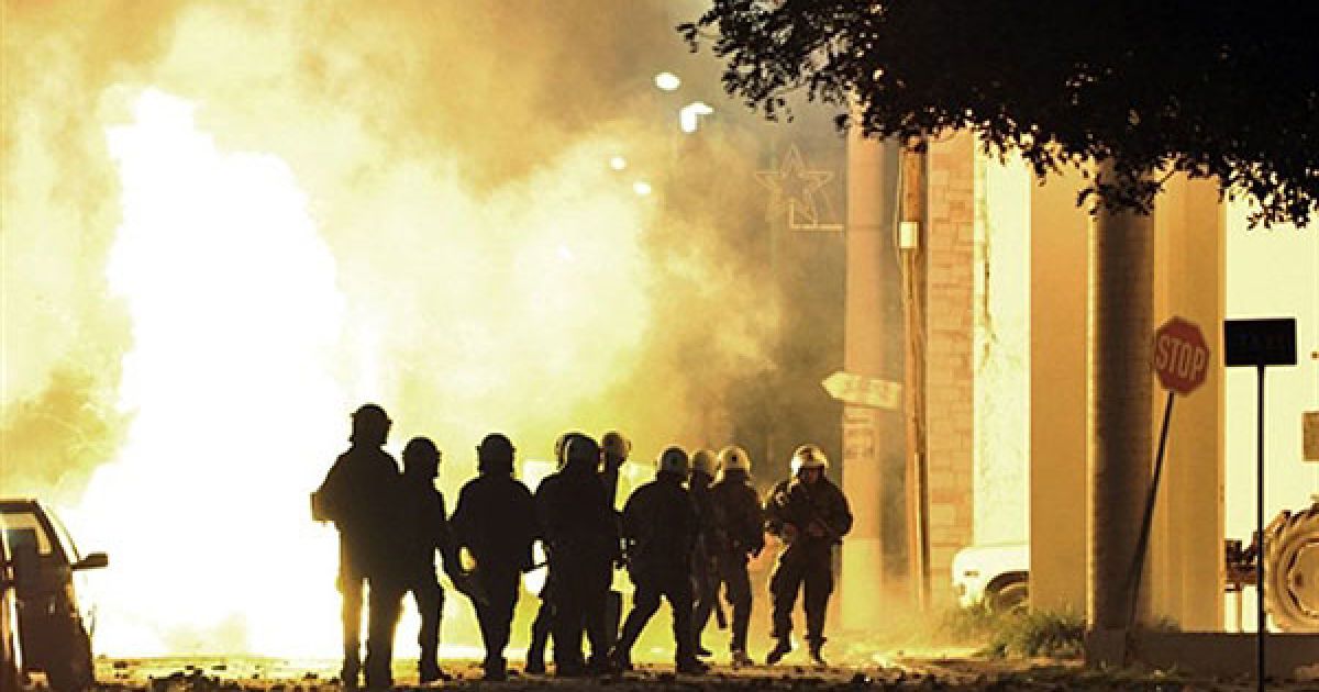 Греція, Кератеа. Фаєр вибухнув перед групою співробітників ОМОНу під час вуличних зіткнень у місті Кератеа поблизу Афін. Три людини були заарештовані, двоє поліцейських отримали поранення під час заворушень, які спалахнули між поліцією та місцевими жителями під час протестів проти будівництва нового звалища. / © AFP