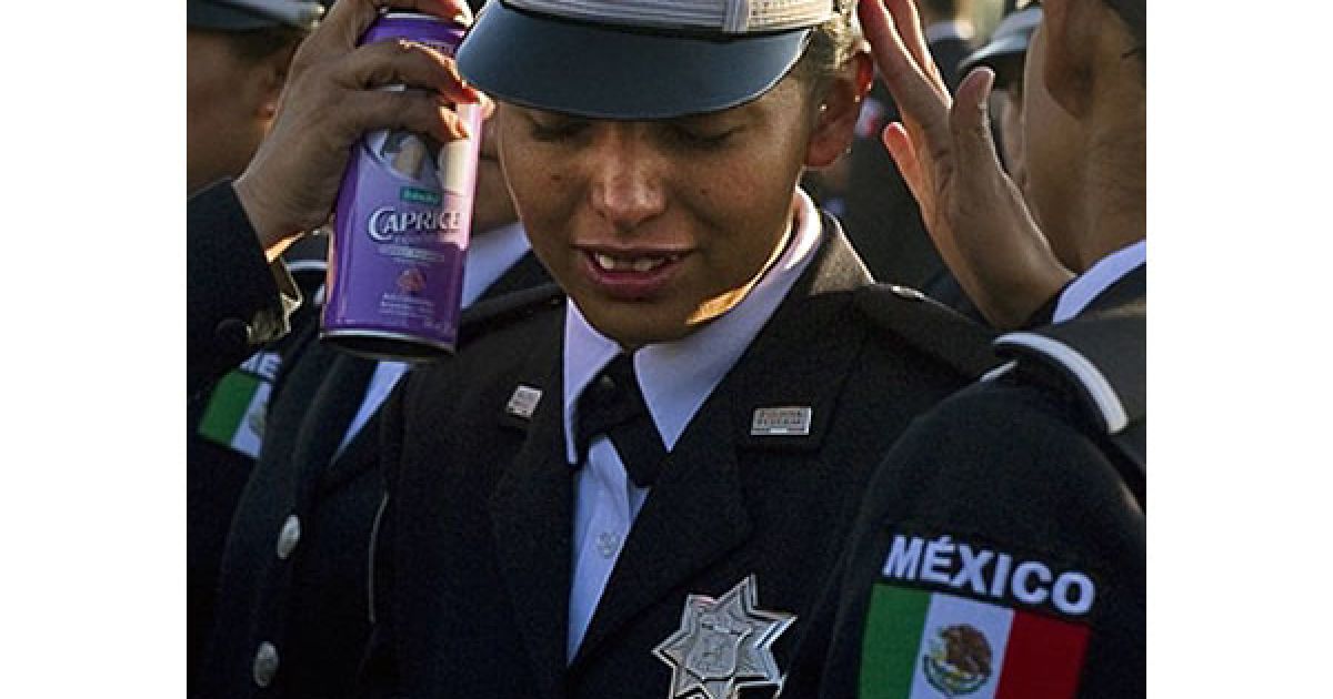 Мексика, Мехіко. Співробітниця мексиканської поліції закріплює лаком зачіску своїй колезі під час презентації трьох вертольотів "Чорний яструб", які уряд США надав федеральній поліції Мексики в рамках Ініціативи Меріда. / © AFP