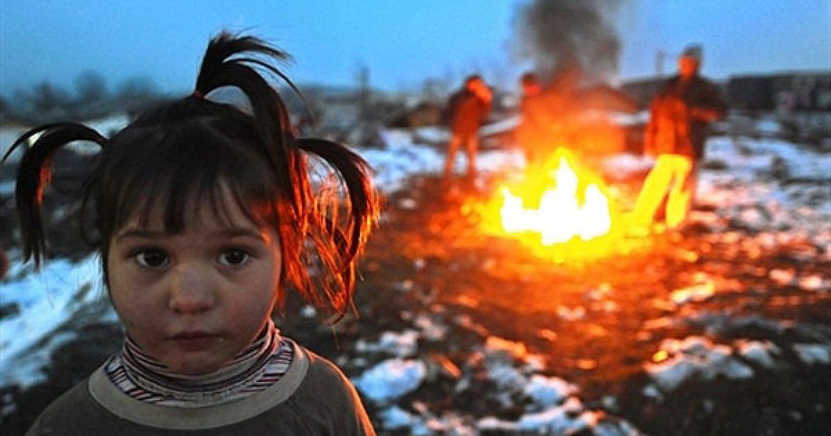 Македонія, Скоп'є. Дівчинка стоїть поруч із вогнищем, біля якого гріються люди на вулиці міста Скоп'є. Македонія потерпає від холодної погоди. / © AFP