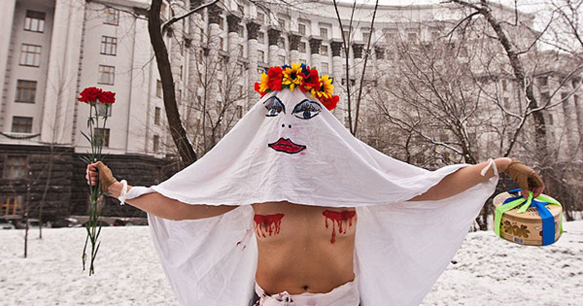 Активістка руху FEMEN в образі "кровосісі" спробувала прорватися до будівлі Кабінету міністрів і особисто вручити Миколі Азарову квіти і торт. / © Жіночий рух FEMEN