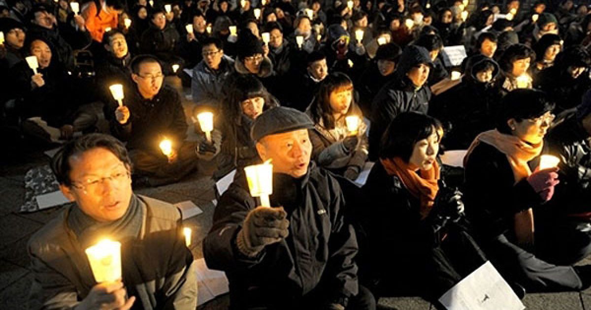 Республіка Корея, Сеул. Південнокорейські демонстранти тримають свічки
під час акції протесту проти спільних військових навчань Південної
Кореї та США. Сполучені Штати і Південна Корея почали великі
військово-морські навчання, призначені для стримування Північної
Кореї, після того, як КНДР попередила про "непередбачувані наслідки"
подібного заходу. / © AFP