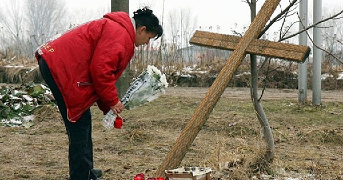 Німеччина, Хордорф. Жінка покладає квіти до імпровізованого хреста, який встановили на місці, де пасажирський поїзд зіткнувся з вантажним поїздом. В результаті аврії, загинули 10 людей, багато осіб отримали поранення. / © AFP