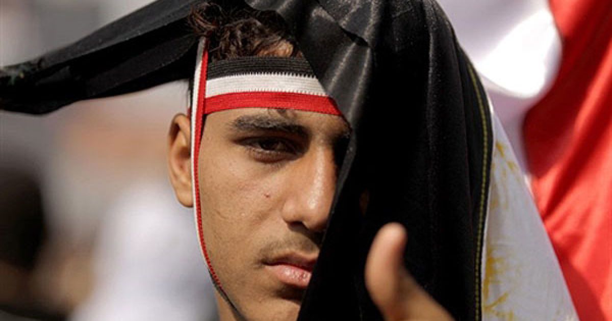 Єгипет, Каїр. Єгипетський учасник антиурядової демонстрації, вкритий національним прапором, бере участь у масовій акції протесту на площі Тахрір в центрі Каїра. В Єгипті триває 16-й день протестів проти 30-річного правління президента Хосні Мубарака. / © AFP