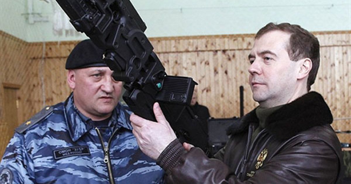 Росія, Щелково. Президент Росії Дмитро Мєдвєдєв роздивляється автомат, яким можна вести вогонь з-за рогу, під час візиту на базу спеціального поліцейського підрозділу "Зубр" у підмосковному місті Щелково. / © AFP
