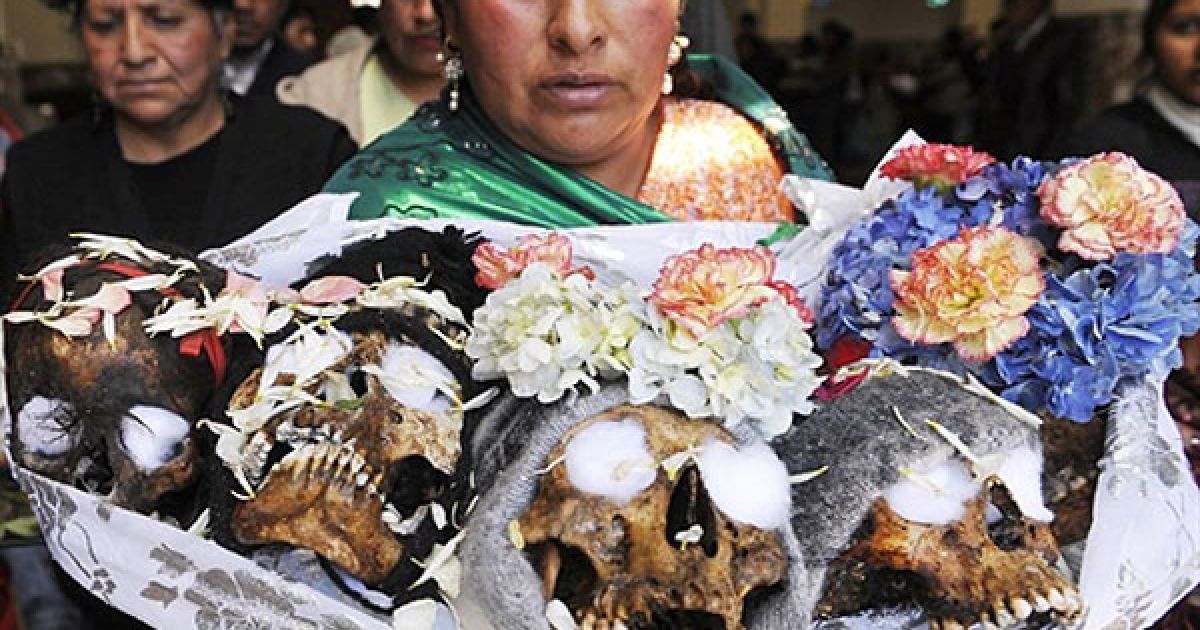 Болівія, Ла-Пас. Жінка несе п'ять черепів під час церемонії вшанування &Ntilde;atitas у День черепа на кладовищі міста Ла-Паc. Цього дня за давньою традицією болівійських Анд черепам родичів або невпізнаних людей "підносять" їжу, алкоголь, цигарки, дякуючи їм за захист. / © AFP