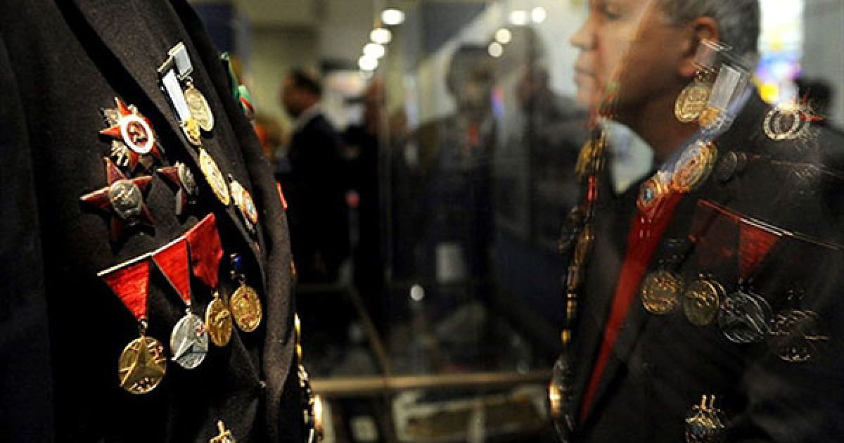 Росія, Москва. Відвідувач роздивляється медалі, вивішені на військовій формі, на виставці, присвяченій 90-річчю служби зовнішньої розвідки у Росії. / © AFP