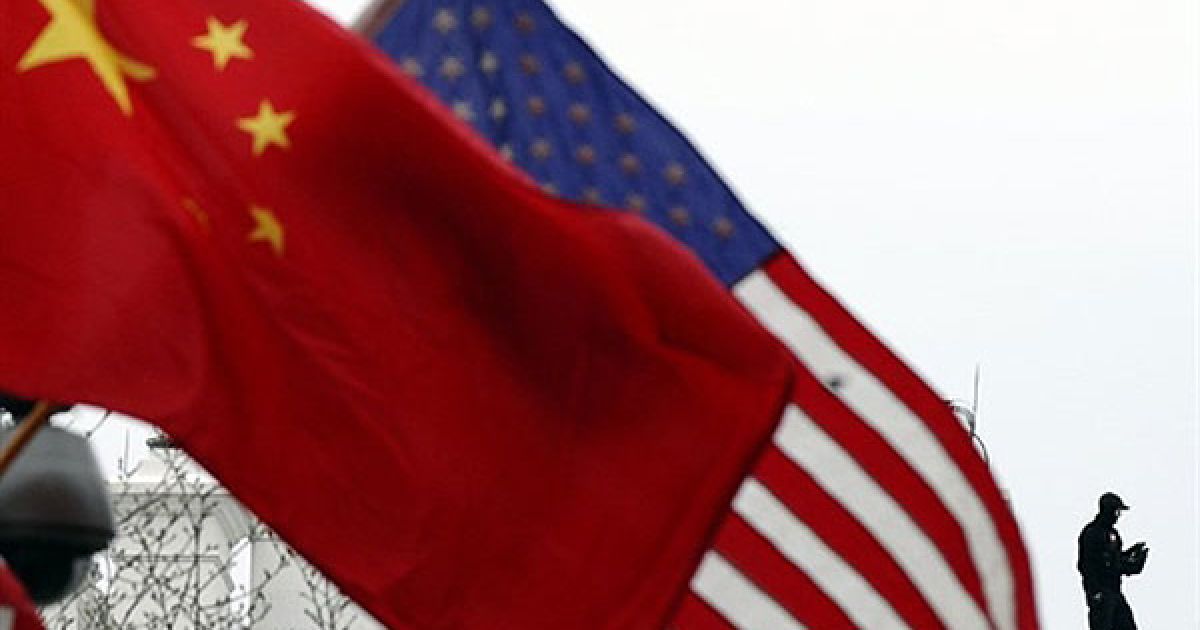 США, Вашингтон. Агент спецслужб стоїть на своєму посту на даху Білого дому, прикрашеного національними китайським та американським прапорами, у Вашингтоні. Президент Китаю Ху Цзіньтао прибув до США з державним візитом. / © AFP