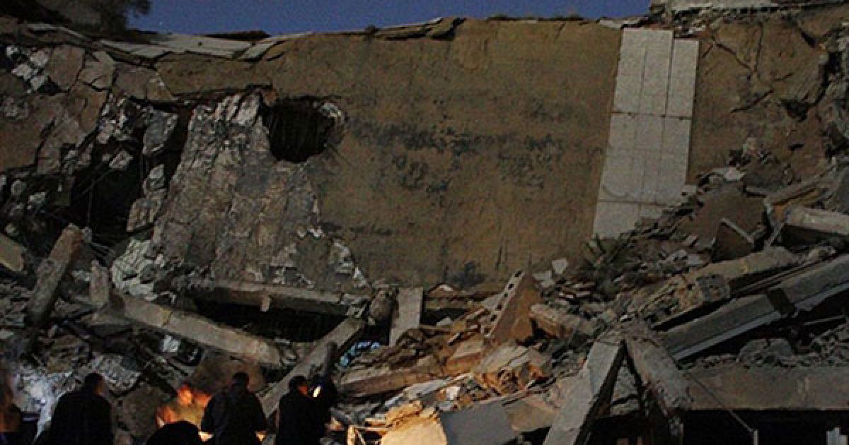 Лівійська Арабська Джамахірія, Тріполі. Люди стоять біля уламків зруйнованої ракетним ударом резиденції лівійського лідера Муаммара Каддафі в Тріполі. Будівлю, розташовану поблизу намету, де Каддафі зазвичай зустрічав гостей, зрівняли з землею. / © AFP