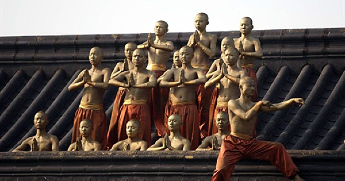 Молоді шаолінські монахи беруть участь у виставі для туристів на честь фестивалю гунфу у китайській провінції Хенань. Зараз монастирі Шаоліню існують переважно за рахунок продажу сувенірів через інтернет та гастрольних виступів. / © AFP