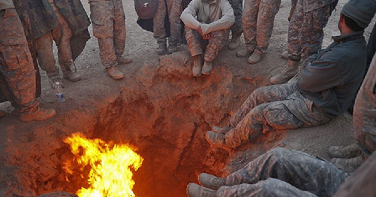 Солдати армії США гріються біля вогнища на своїй базі Кандагарі. Зараз на території Афганістану перебувають 150 тисяч американських солдатів, але згідно із стратегією Барака Обами, яку він оприлюднив, американський контингент буде зменшено до 30 тисяч. / © AFP