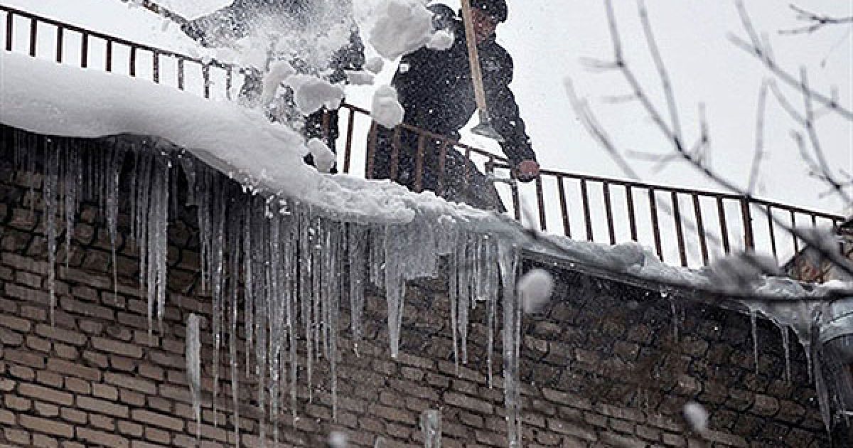 Білорусь, Мінськ. Муніципальні працівники збивають з даху однієї з будівель у Мінську небезпечні бурульки. / © AFP