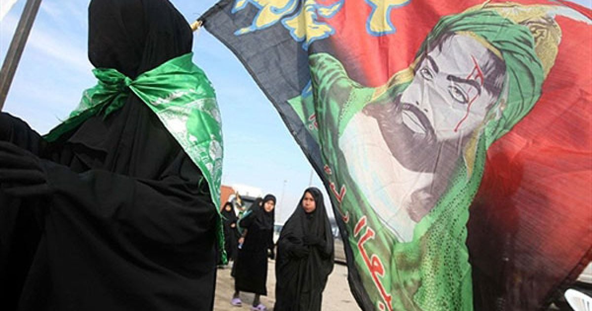 Ірак, Багдад. Шиїтська мусульманська жінка тримає в руках прапор із зображенням шиїтського імама Хусейна, доки вона разом з іншими віруючими прямує з Багдада до іракського міста Кербела. Шиїти відзначають 40-й день після Ашури. / © AFP