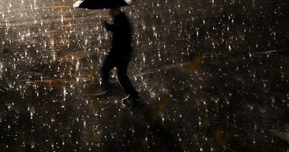 Сербія, Пріштіна. Чоловік із парасолькою йде під час сильного дощу вулицею міста Пріштіна, Косово. / © AFP