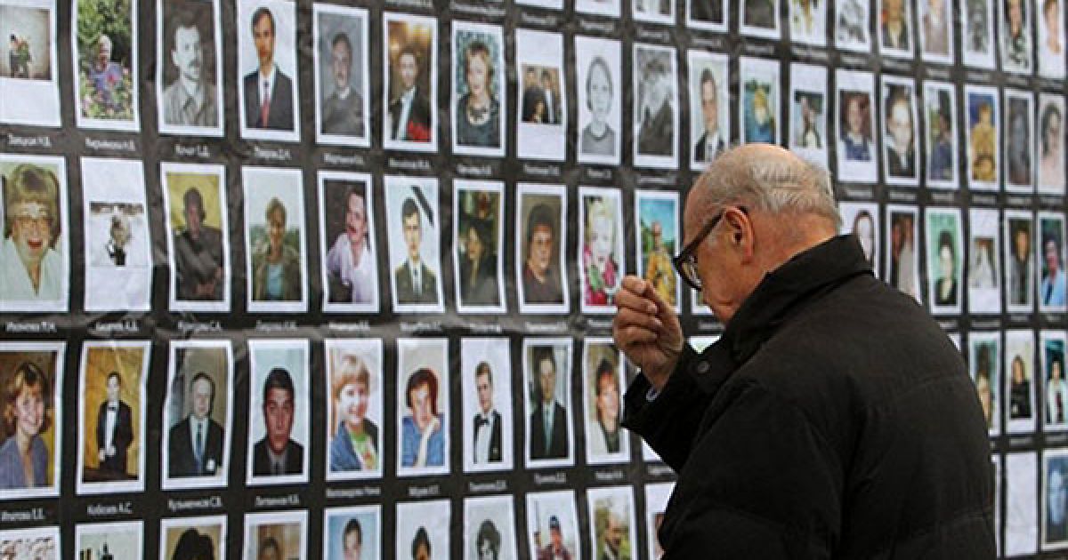 Росія, Москва. Чоловік хреститься перед портретами заручників, що стали жертвами "трагедії Норд-Осту", яка сталася у 2002 році в Москві. Під час мюзиклу, який проходив у театрі на Дубровці, бойовики захопили в заручники майже 800 людей. Дії російських спецслужб зі звільнення заручників призвели до загибелі 130 чоловік, у тому числі 17 акторів і музикантів. / © AFP