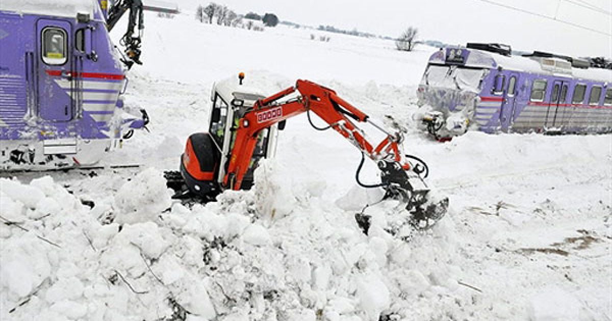 Швеція, Балкакра. Люди прибирають сніг за допомогою екскаваторів з рейок, на яких снігопад заблокував два місцевих поїзди на півдні Швеції. / © AFP