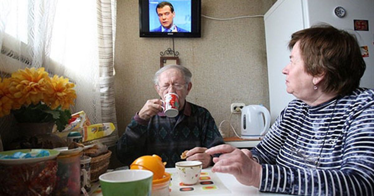 Росія, Санкт-Петербург. Люди п'ють чай у своїй квартирі в Санкт-Петербурзі під час прямої трансляції зустрічі президента Росії Дмитра Мєдвєдєва з керівниками головних національних телеканалів. Медведєв заявив у п'ятницю, що жоден російський чиновник не повинен коментувати судову справу до винесення вироку. Можливо він мав на увазі зауваження прем'єр-міністра Володимира Путіна щодо Михайла Ходорковського. / © AFP