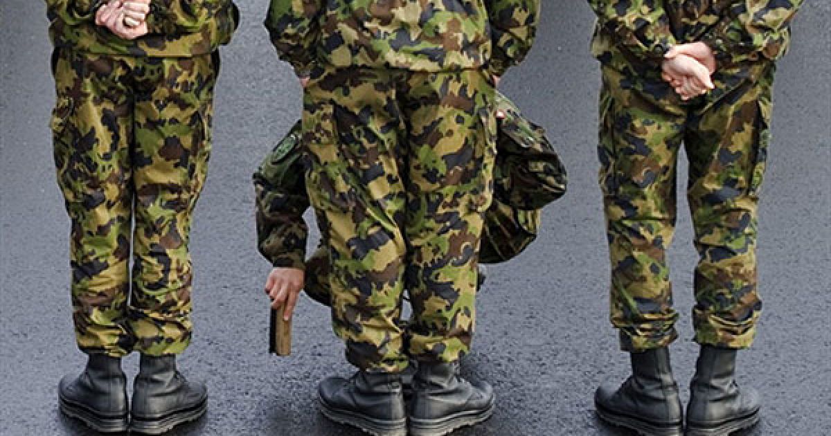 Швейцарія, Клотен. Швейцарський солдат чистить черевики свого колеги перед початком офіційної зустрічі президента Туреччини Абдулли Гюля в аеропорту Цюріха. Гюль прибув до Швейцарії з дводенним державним візитом. / © AFP