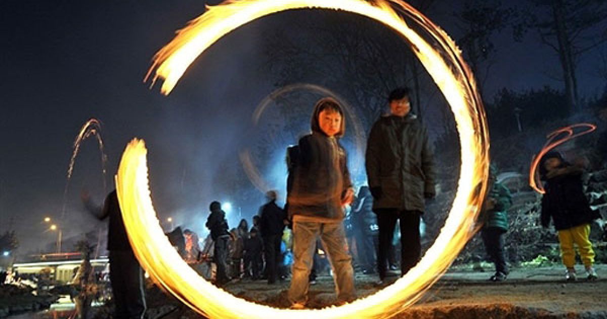 Республіка Корея, Сеул. Південнокорейський хлопчик грає з фарами під час святкування першого повного місяця у цьому місячному Новому році. / © AFP