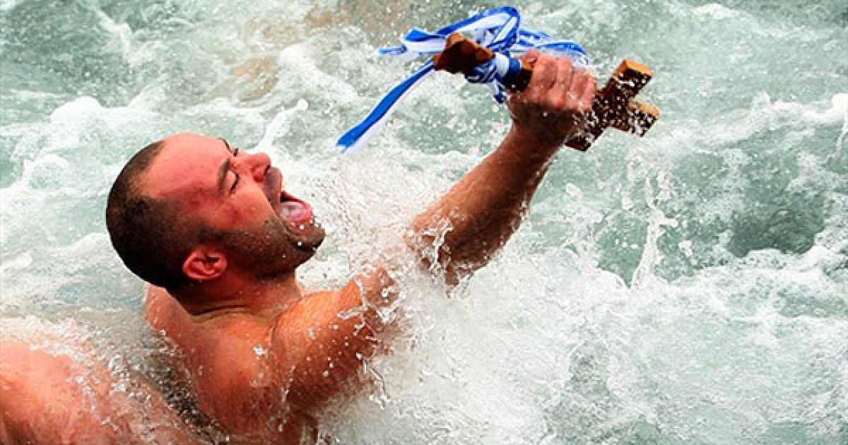 Греція, Салоніки. Чоловік тримає дерев'яний хрест, який він зловив у морі під час церемонії Хрещення у північному порту Греції, Салоніках.