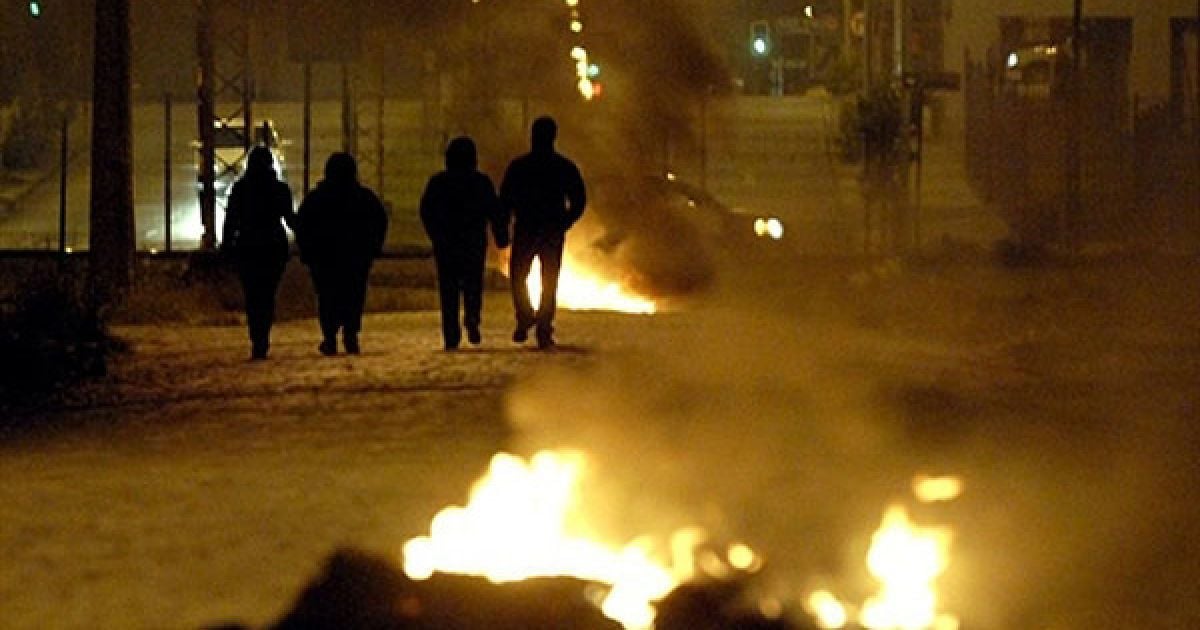 Чилі, Консепсьйон. Місцеві мешканці проходять повз барикади, встановлені під час акцій протесту проти повільного прогресу в реконструкції, які провели через рік після руйнівного землетрусу і цунамі, які обрушилися на країну, і в резльтаті яких загинули 524 людини. / © AFP