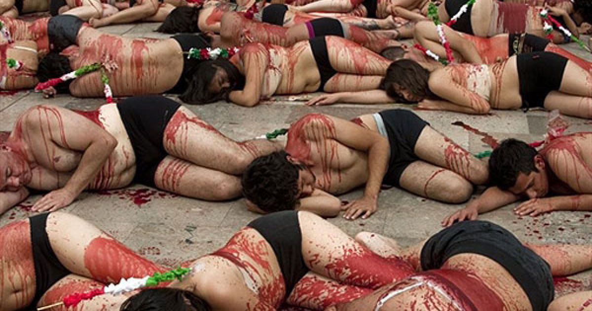 Мексика, Мехіко. Члени організації Anima Naturalis, вимазані штучною кров'ю, лежать під час акції протесту проти проведення кориди, яку вони влаштували перед Палацом витончених мистецтв у Мехіко. / © AFP