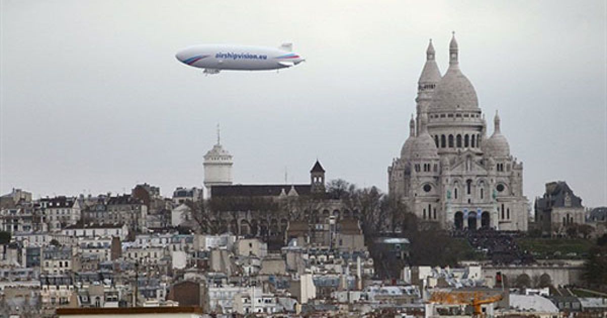 Франція, Париж. Дирижабль "Zeppelin" пролітає повз дах собору Сакре-Кер у Парижі. Дирижаблі вимірюють рівня радіоактивності у Парижі. / © AFP