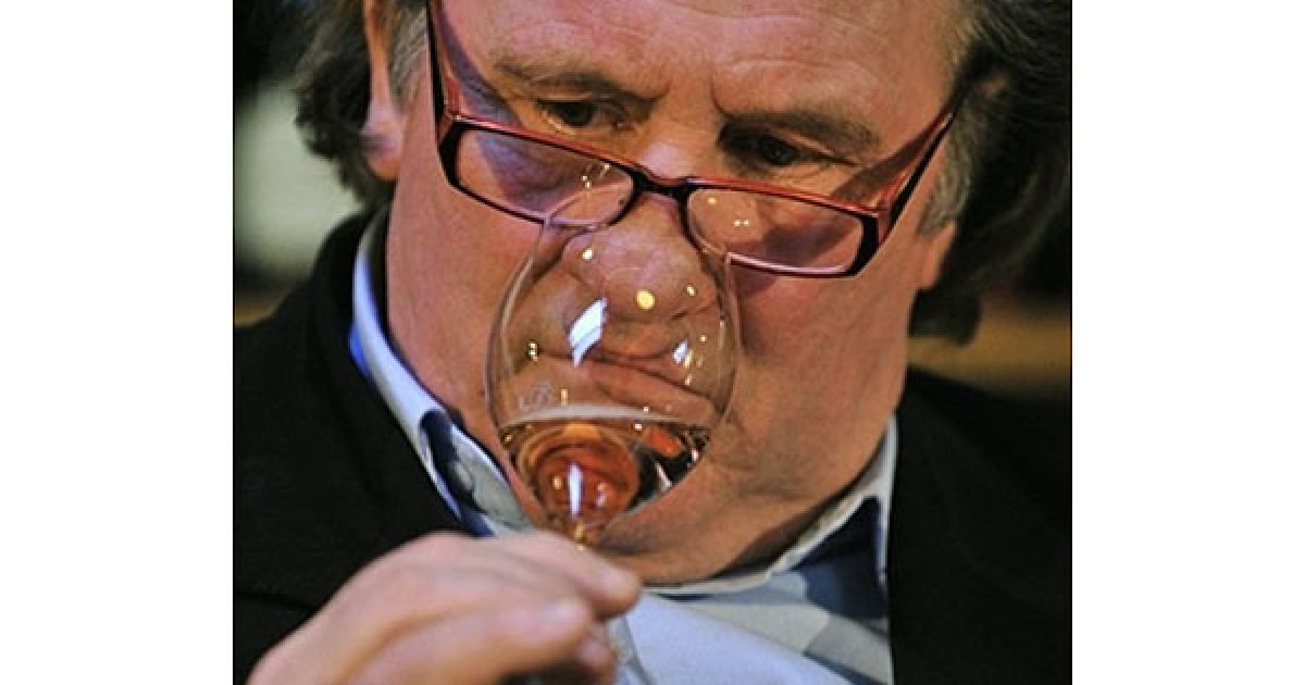 Німеччина, Берлін. Французький актор Жерар Депардьє нюхає зразок
ігристого рожевого вина під час презентації у винному магазині у
Берліні, в якому Депардьє представив брют власного виробництва. / © AFP