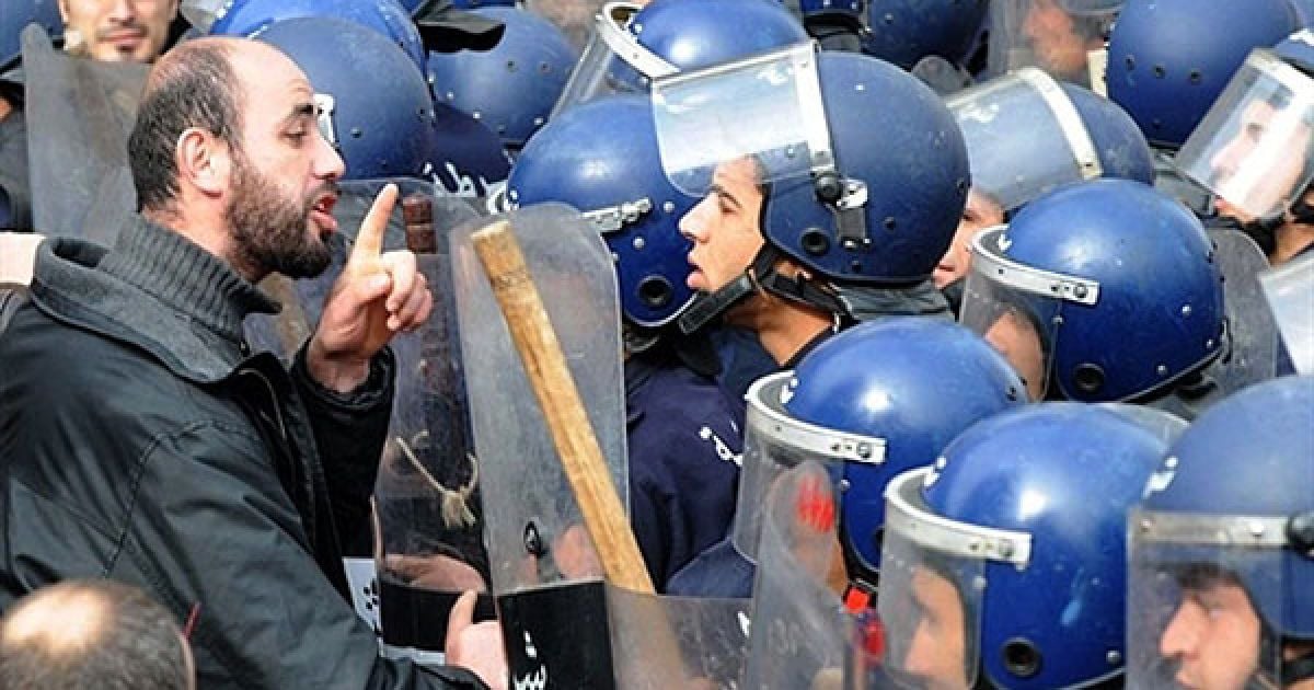 Алжир. Людина розмовляє з поліцейськими, які оточили демонстрантів у Алжирі. Близько 200 алжирських протестуючих провели мітинг на центральній площі у Алжирі. / © AFP