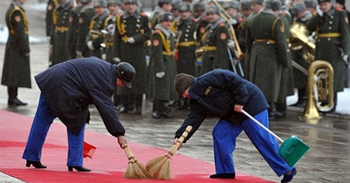 Україна, Київ. Жінки чистять килимову доріжку перед почесною вартою під час церемонії зустрічі президента України Віктора Януковича і прем&#039;єр-міністра Туреччини Тайіпа Ердогана у Києві. / © AFP