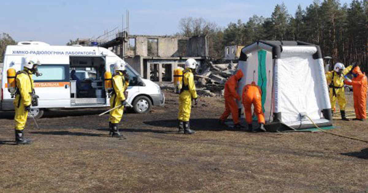 Співробітники МНС в костюмах хімзахисту біля автомобіля пересувної химіко-радіологічної лабораторії / © УНІАН