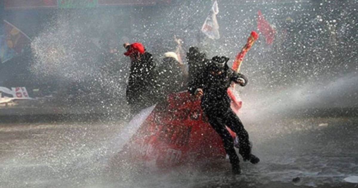 Туреччина, Анкара. Демонстранти намагаються захистити себе плакатами від водометів, які поліція використала для розгону акції протесту в Анкарі. Поліція використала сльозогінний газ і водомети для розгону тисяч робітників, які вийшли на вулиці на знак протесту проти спірного законопроекту про трудові права.