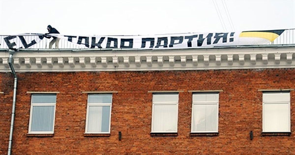 Росія, Москва. Активіст руху "Інша Росія" розгортає прапор партії на даху Міністерства юстиції Росії під час акції протесту в Москві. / © AFP