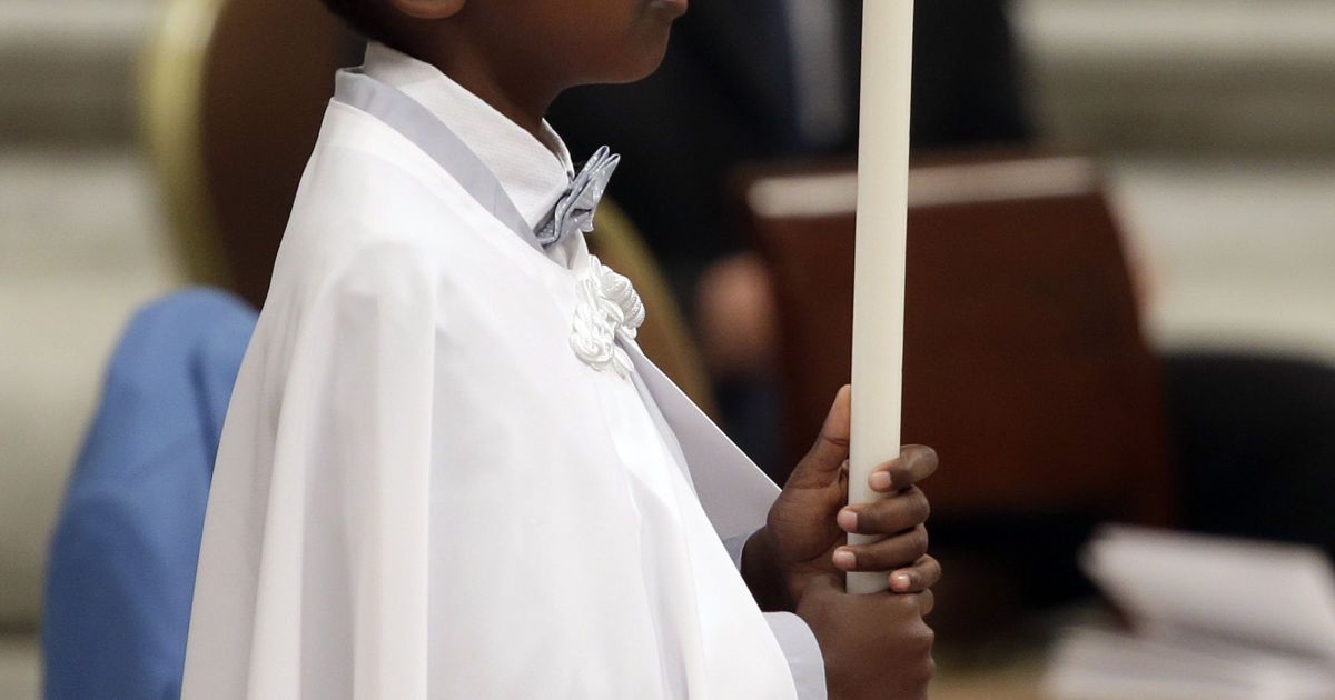 Хлопчик тримає свічку після того, як папа римський його охрестив, Ватикан / © Reuters