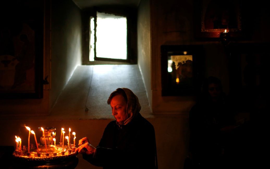 Жінка запалює свічку в Тбілісі, Грузія / © Reuters