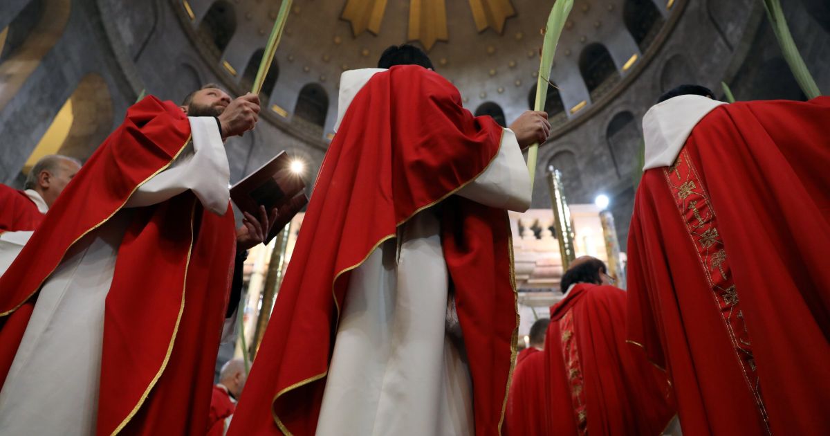 Члены католического духовенства принимают участие в церемонии Вербного воскресенья в храме Гроба Господня в Старом городе Иерусалима / © Reuters