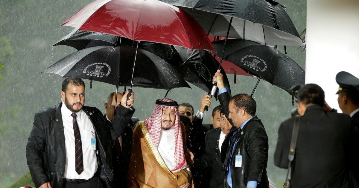 Король Салман и президент Индонезии Джоко Видодо идут под зонтами / © Reuters