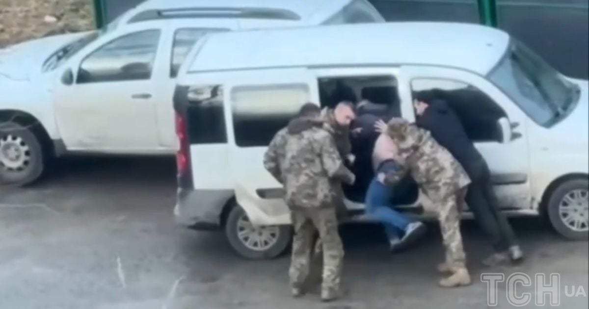 Троє людей у військовій формі досить грубо заштовхували чоловіка до білого буса