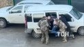 Три человека в военной форме довольно грубо заталкивали мужчину в белый бус
