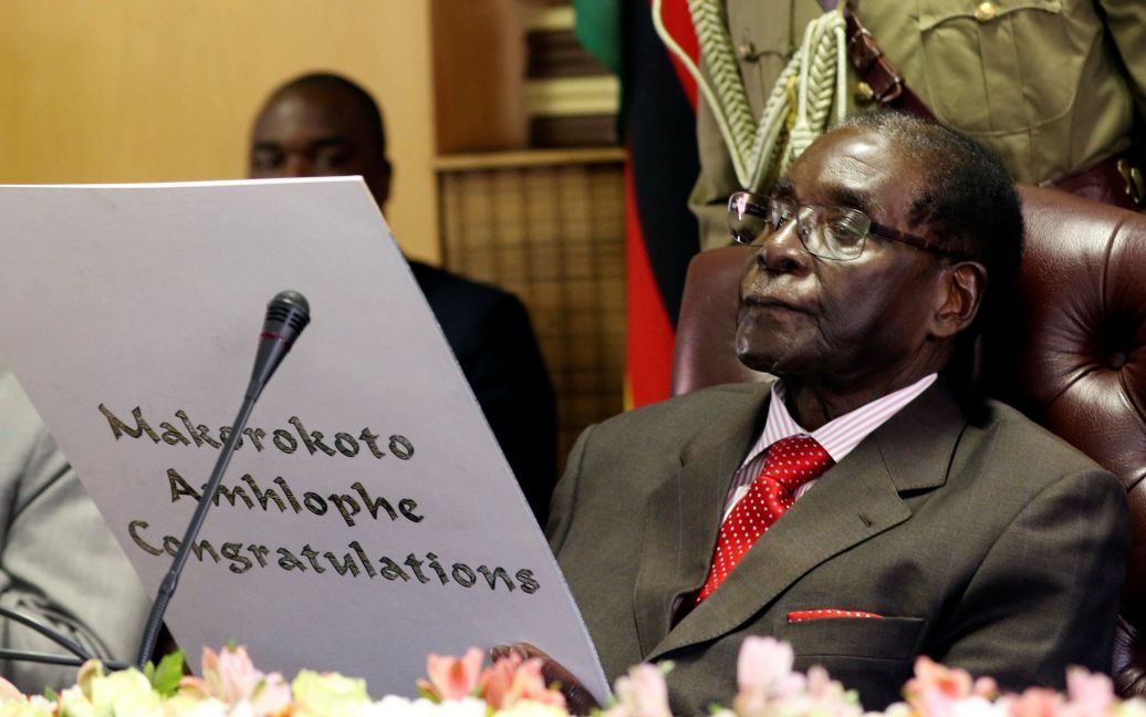 Президент Зимбабве Роберт Мугабе читает поздравительную открытку во время торжеств по случаю празднования его 93-го дня рождения в Хараре, Зимбабве. / © Reuters