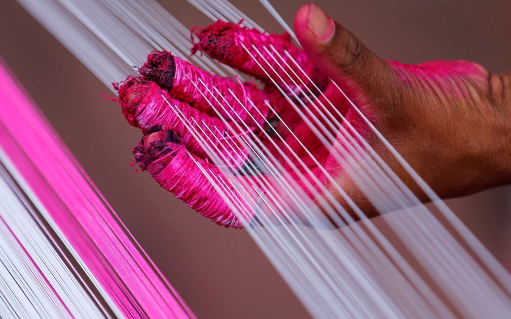 Працівник використовує кольорові рядки, які будуть використовуватис для виготовлення повітряних зміїв в Ахмадабаді, Індія. / © Reuters