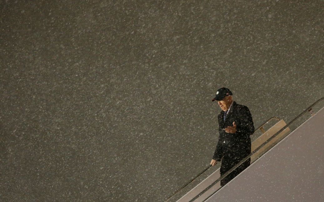 Вице-президент США Джо Байден сходит со своего самолета в метель после прибытия в международный аэропорт Оттавы в Канаде. / © Reuters
